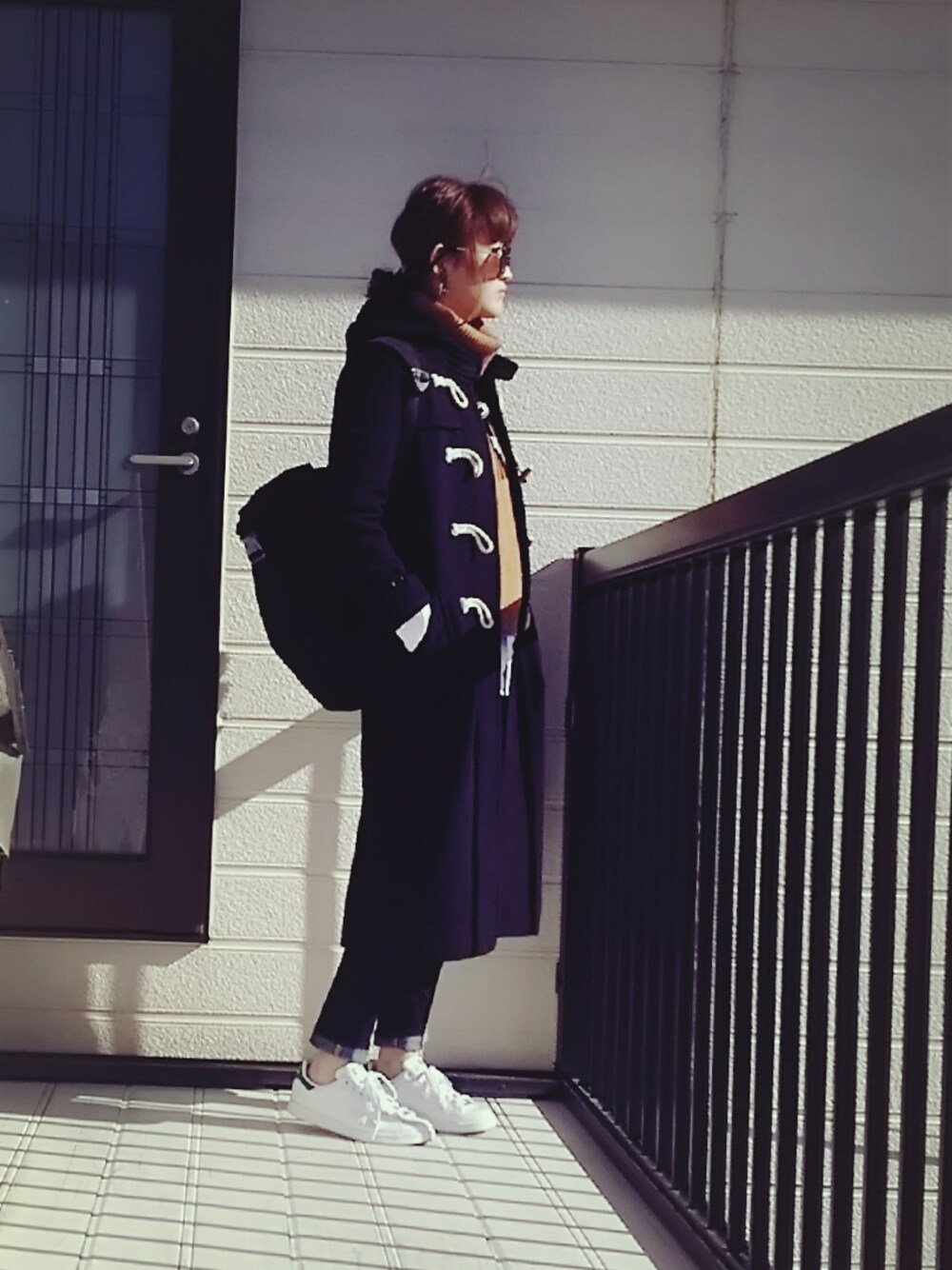 ブラウン系のベスト、ブラック系のダッフルコート、ブラック系のバックパック/リュックを着用したレディースの冬コーディネートの1枚目の写真