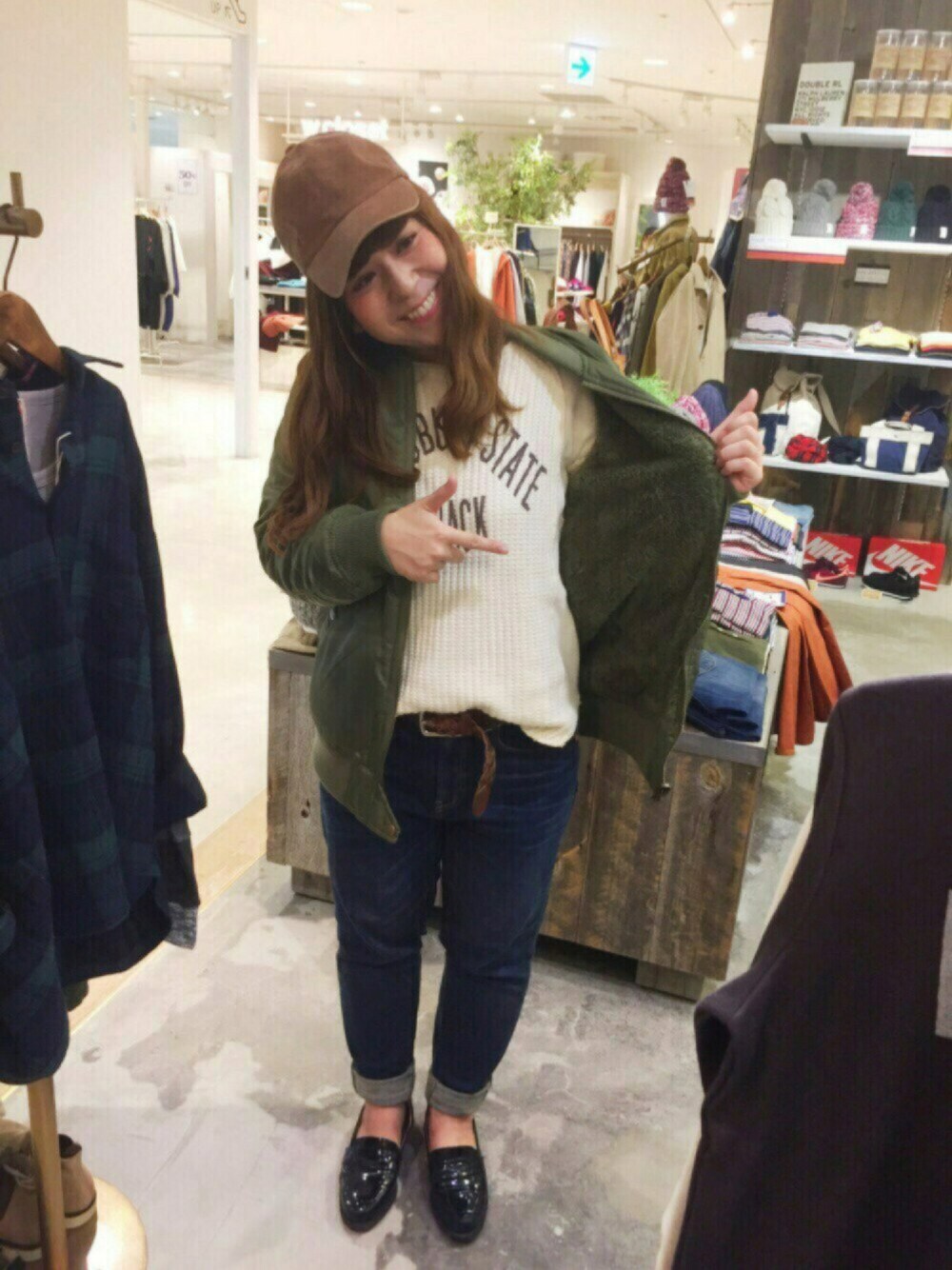 グリーン系のMA-1、ベージュ系のTシャツ/カットソー、ブルー系のデニムパンツを着用したレディースの秋コーディネートの1枚目の写真