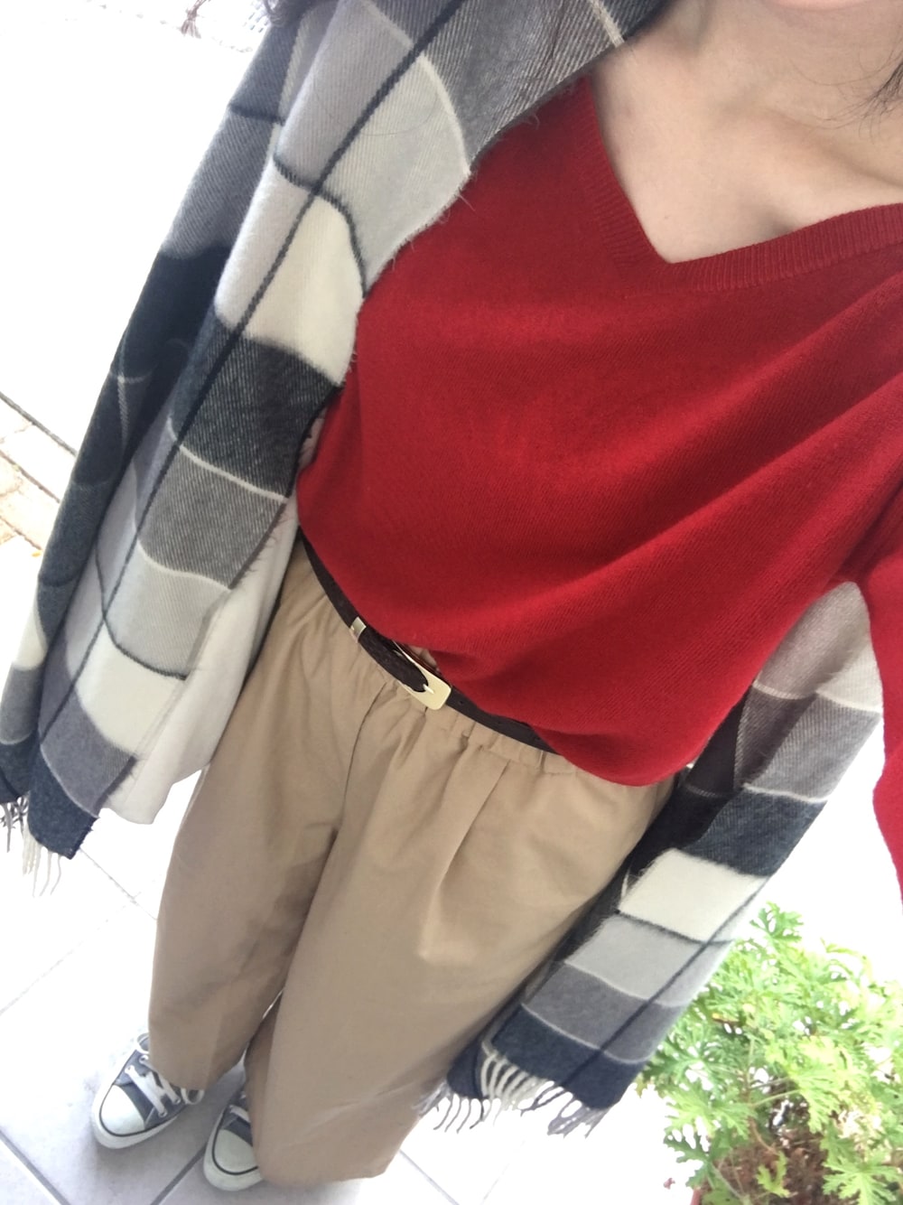 レッド系のニット/セーター、ベージュ系のその他パンツ、グレー系のスニーカーを着用したレディースの秋コーディネートの1枚目の写真