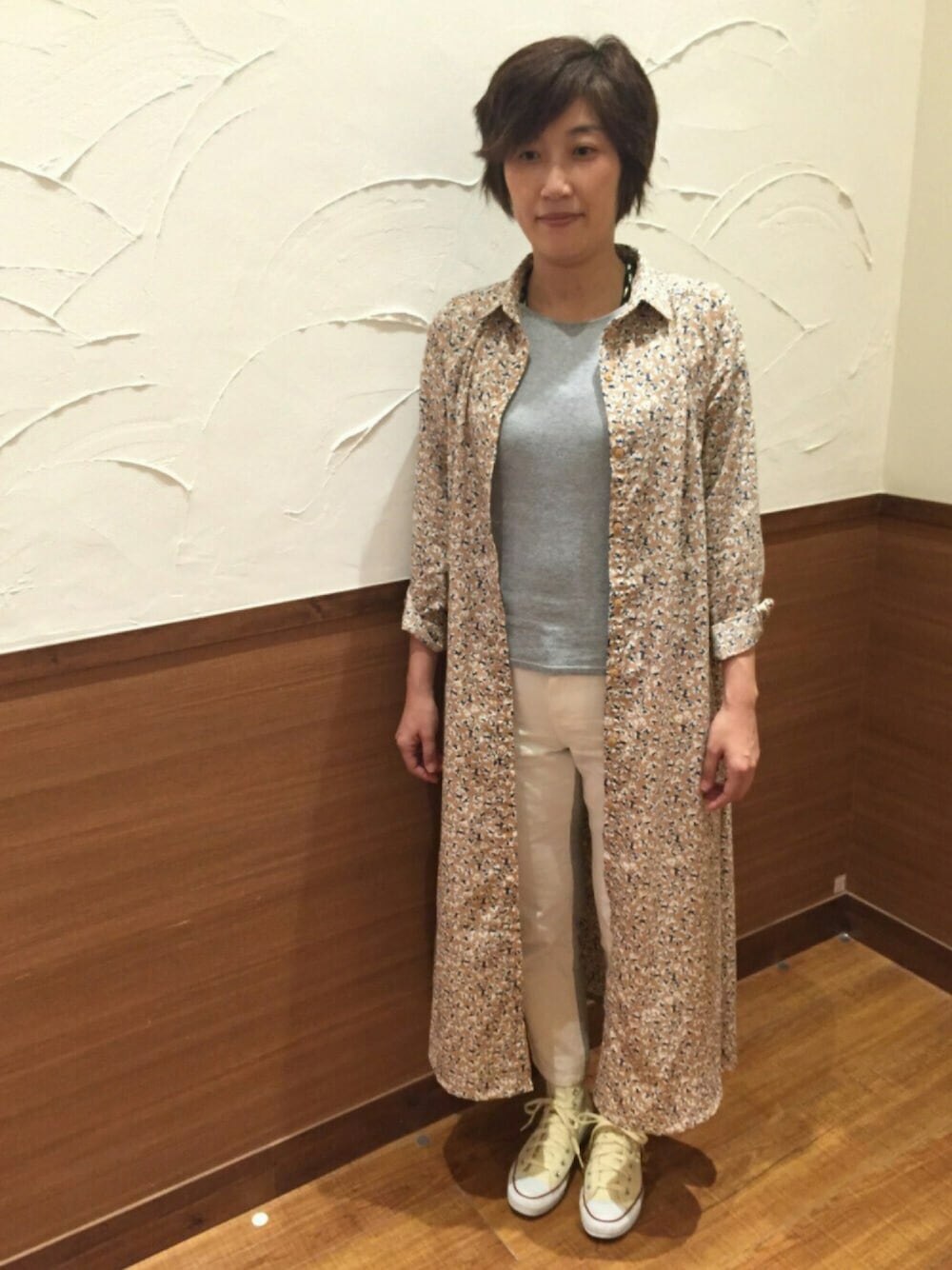 ベージュ系のシャツワンピース、ホワイト系のその他パンツ、ホワイト系のスニーカーを着用したレディースの春コーディネートの1枚目の写真