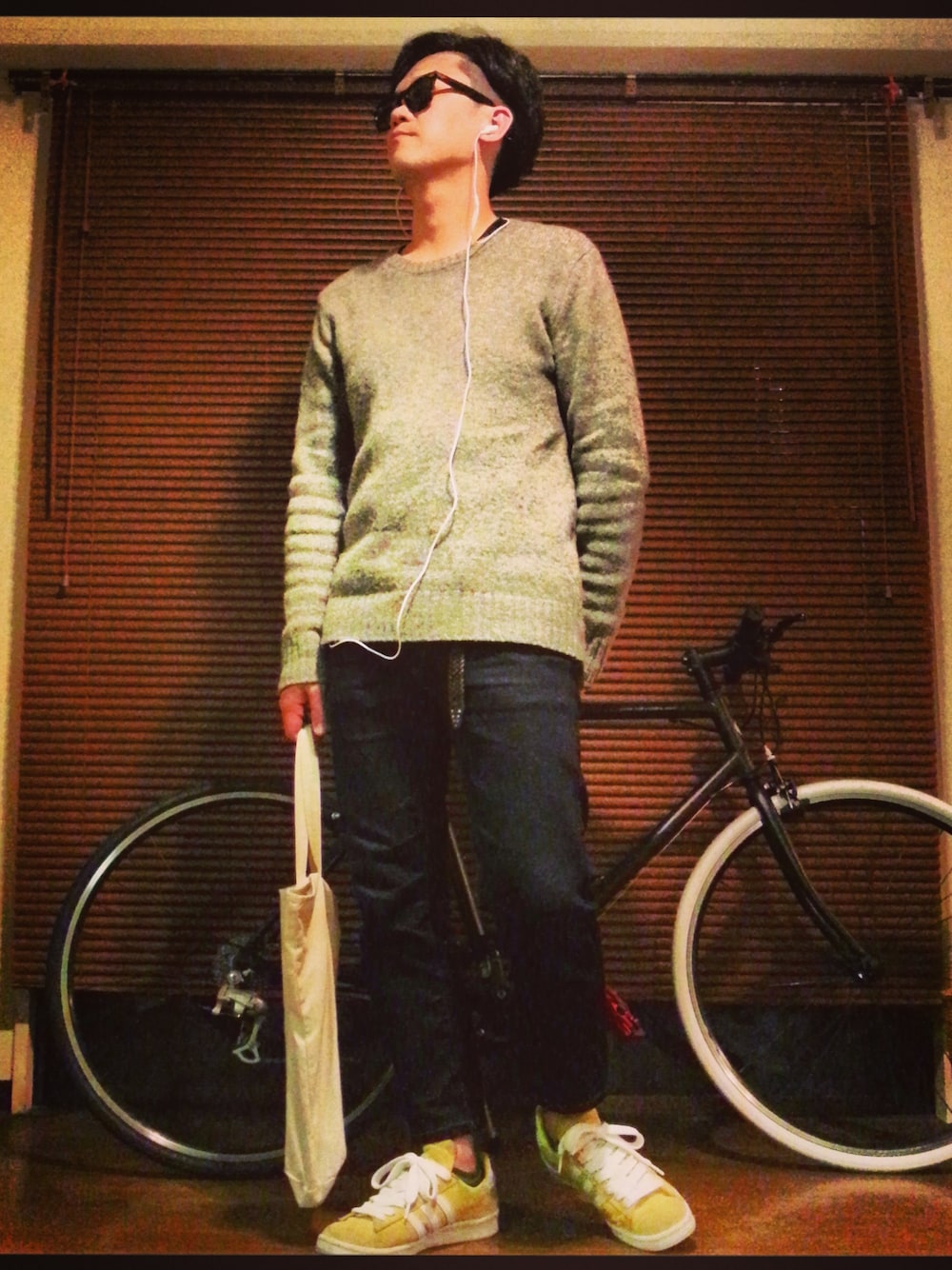 イエロー系のスニーカー、グレー系のニット/セーター、ブラック系のスマホケース/カバーを着用したメンズの春コーディネートの1枚目の写真