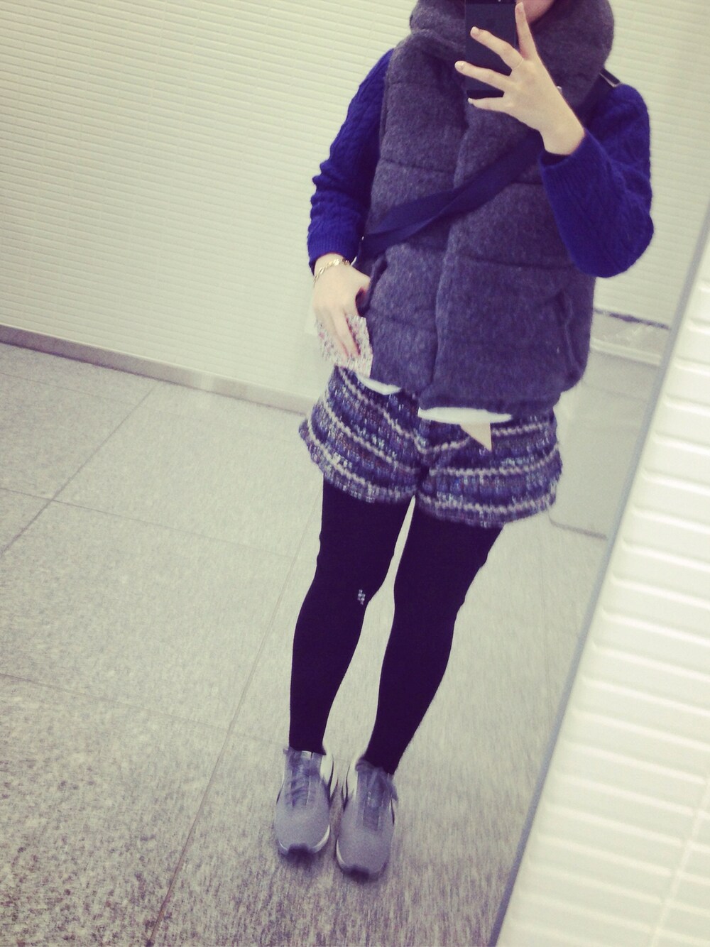 ブラック系のスニーカー、ダウンベストを着用したレディースの冬コーディネートの1枚目の写真