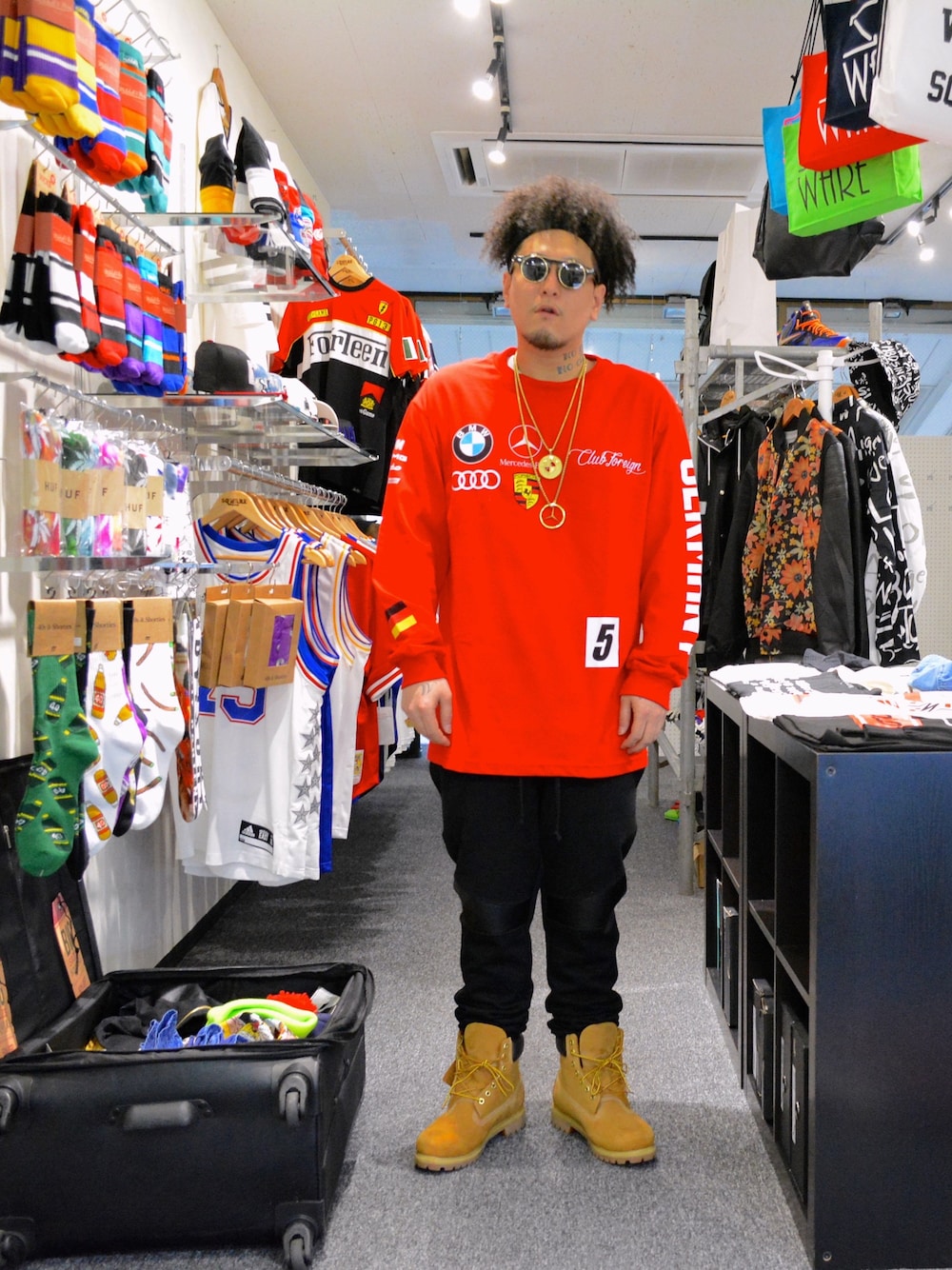 レッド系のTシャツ/カットソー、ブラック系のその他パンツ、イエロー系のブーツを着用したメンズの春コーディネートの1枚目の写真