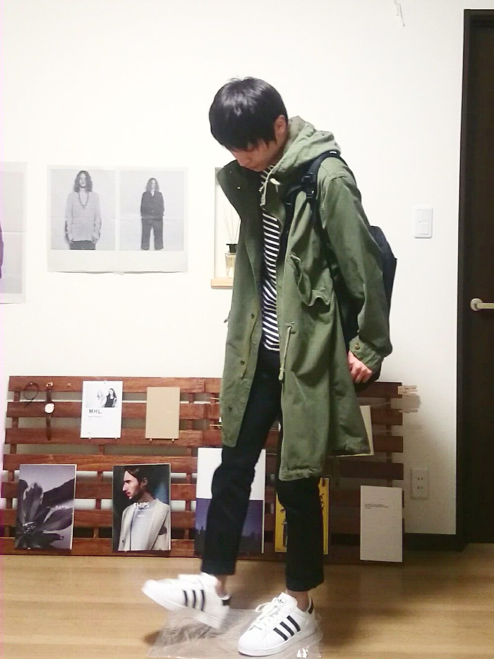 ホワイト系のスニーカー、ブラック系のデニムパンツ、ブラック系のバックパック/リュックを着用したメンズの秋コーディネートの1枚目の写真