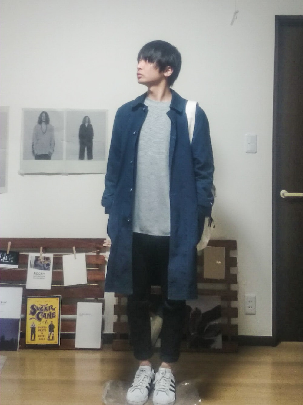 グレー系のニット/セーター、ホワイト系のスニーカー、ブルー系のジャケット/アウターを着用したメンズの春コーディネートの1枚目の写真
