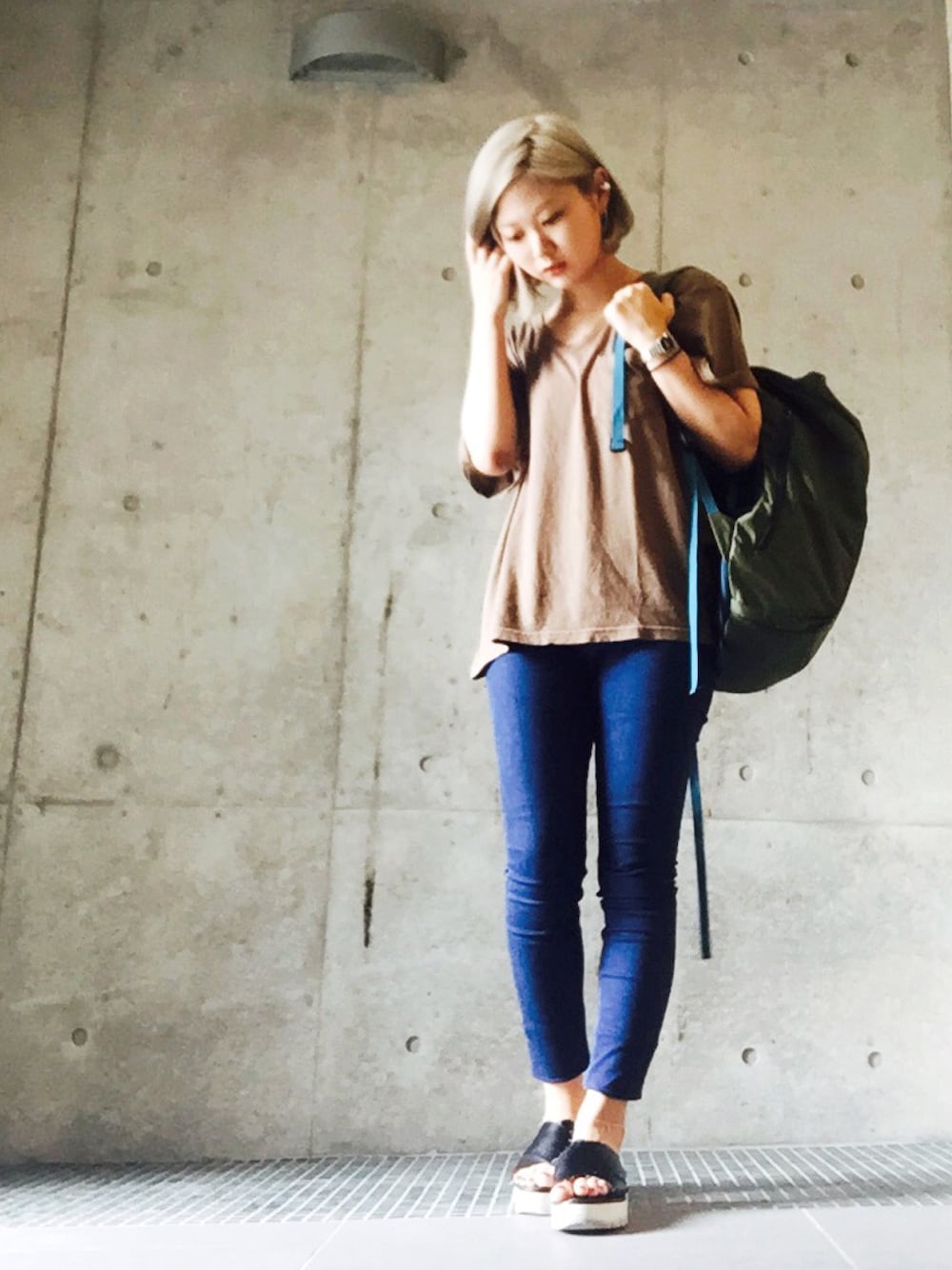 ブルー系のデニムパンツ、グリーン系のバックパック/リュック、シルバー系のアンクレットを着用したレディースの夏コーディネートの1枚目の写真