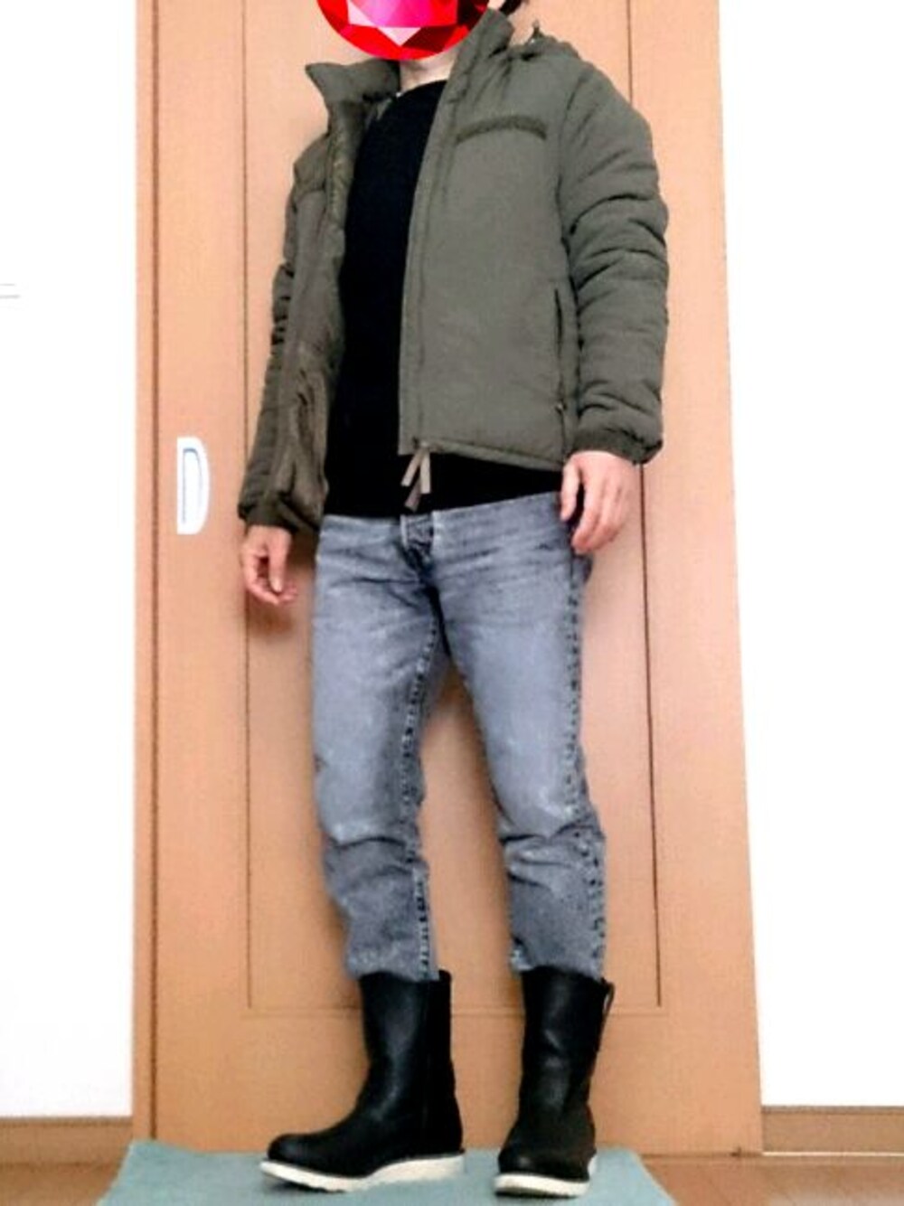 グリーン系のミリタリージャケット、ブラック系のニット/セーター、ブラック系のデニムパンツを着用したメンズの冬コーディネートの1枚目の写真