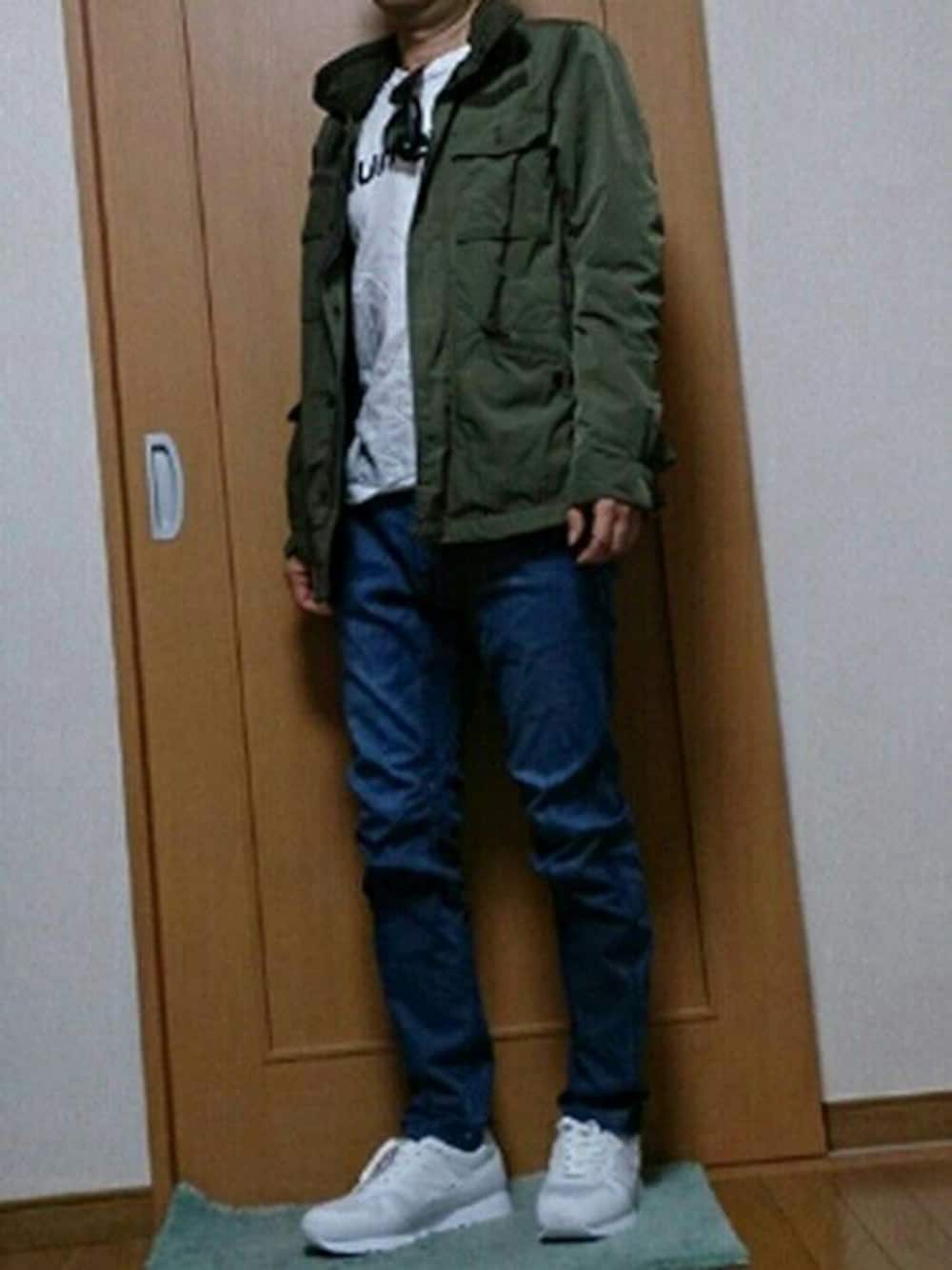 グリーン系のミリタリージャケット、ホワイト系のTシャツ/カットソー、ブルー系のデニムパンツを着用したメンズの秋コーディネートの1枚目の写真
