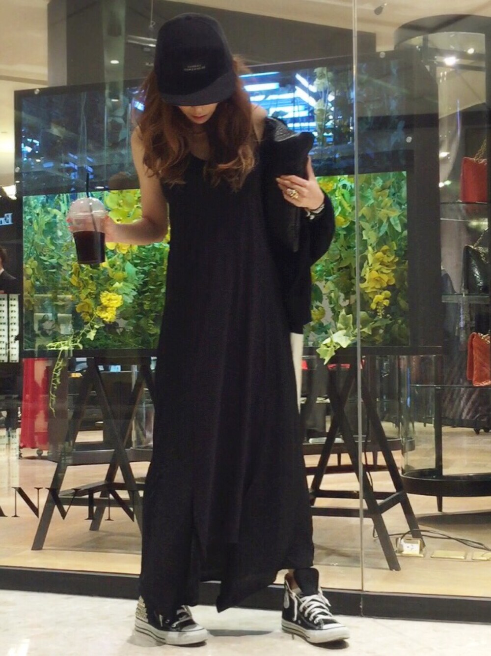 ブラック系のワンピース、ブラック系のスニーカー、ブラック系のクラッチバッグを着用したレディースの夏コーディネートの1枚目の写真