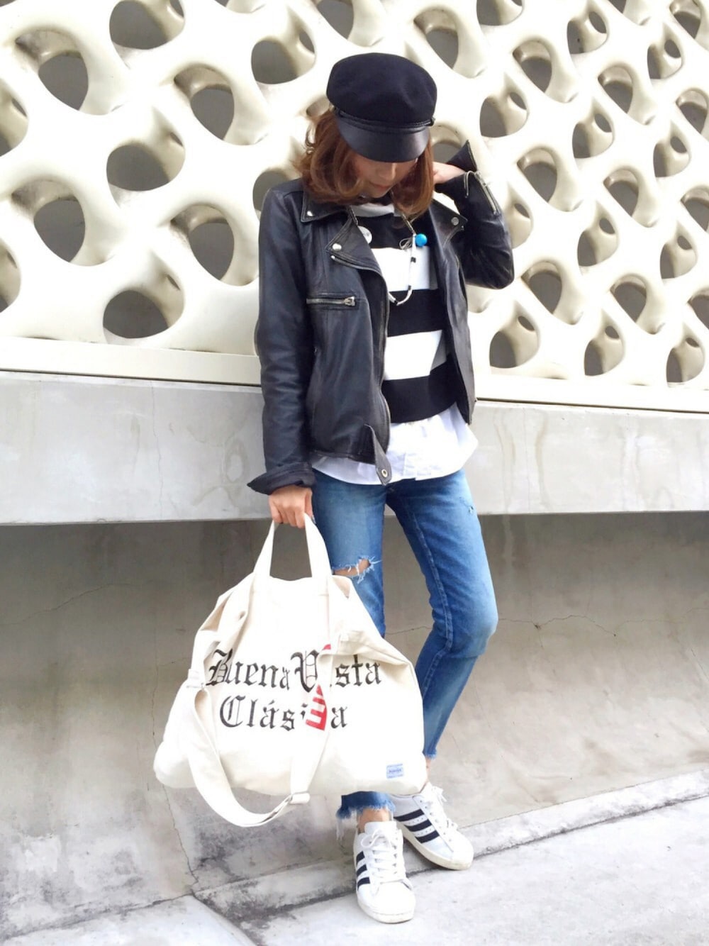 ブラック系のライダースジャケット、ホワイト系のニット/セーター、ホワイト系のシャツ/ブラウスを着用したレディースの冬コーディネートの1枚目の写真