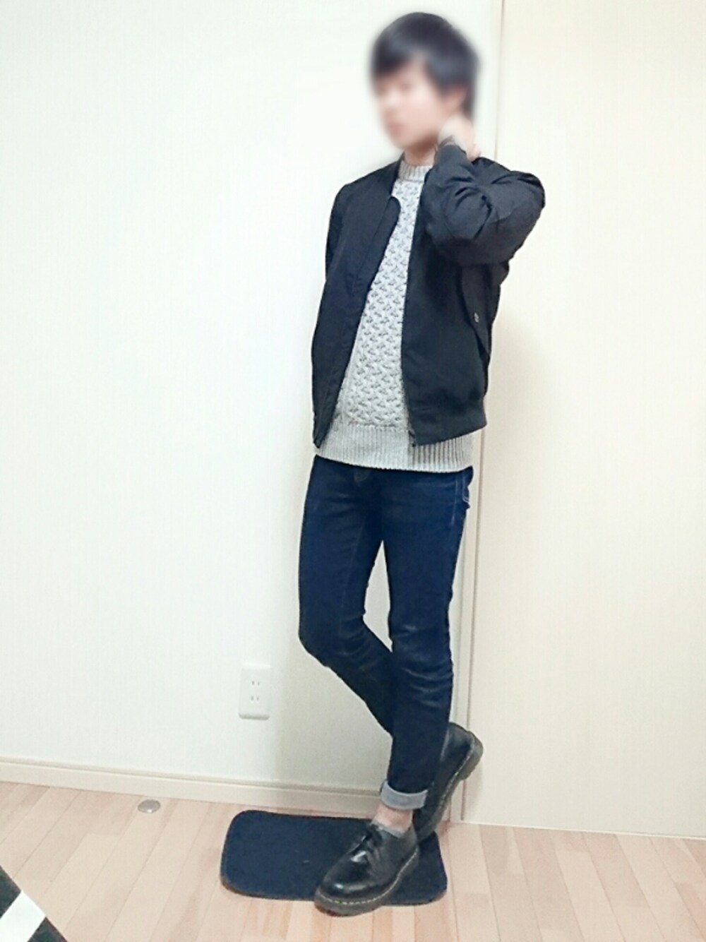 グレー系のニット/セーター、ブラック系のブルゾン、ブルー系のパンツを着用したメンズの秋コーディネートの1枚目の写真