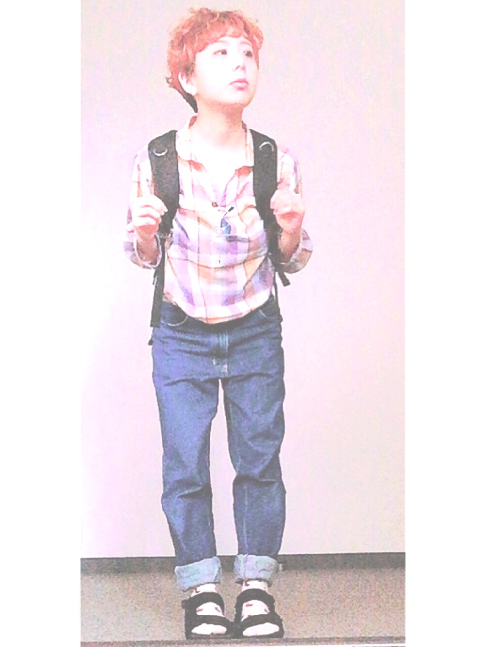 パープル系のトップス、ブルー系のデニムパンツ、ブラック系のサンダルを着用したレディースの夏コーディネートの1枚目の写真