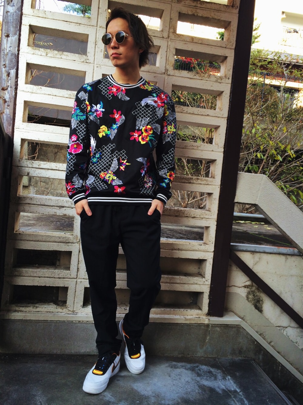 ブラック系のその他トップス、ブラック系のスラックス、ホワイト系のスニーカーを着用したメンズの冬コーディネートの1枚目の写真