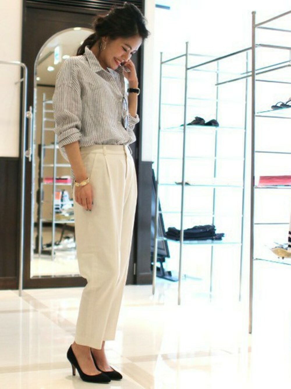 ブラック系のシャツ/ブラウス、ブラック系のパンプス、ホワイト系のその他パンツを着用したレディースの春コーディネートの1枚目の写真