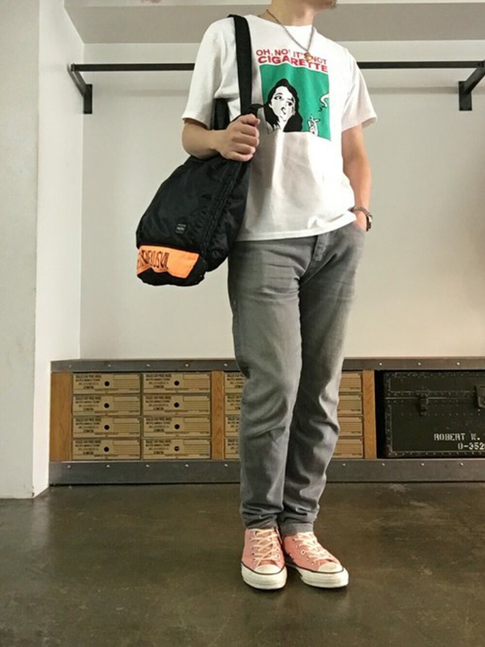 ホワイト系のTシャツ/カットソー、グレー系のデニムパンツ、ブラック系のバックパック/リュックを着用したメンズの春コーディネートの1枚目の写真