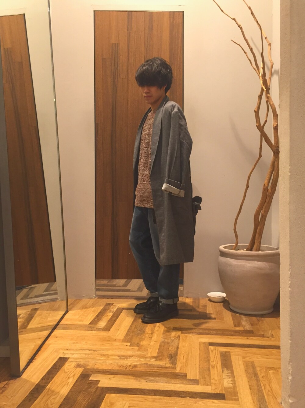グレー系のシャツ/ブラウス、ブラウン系のニット/セーター、ブルー系のデニムパンツを着用したメンズの秋コーディネートの1枚目の写真