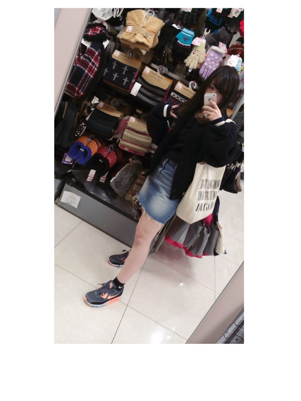 ブルー系のニット/セーター、ホワイト系のエコバッグ/サブバッグ、ブルー系のデニムスカートを着用したレディースの冬コーディネートの1枚目の写真