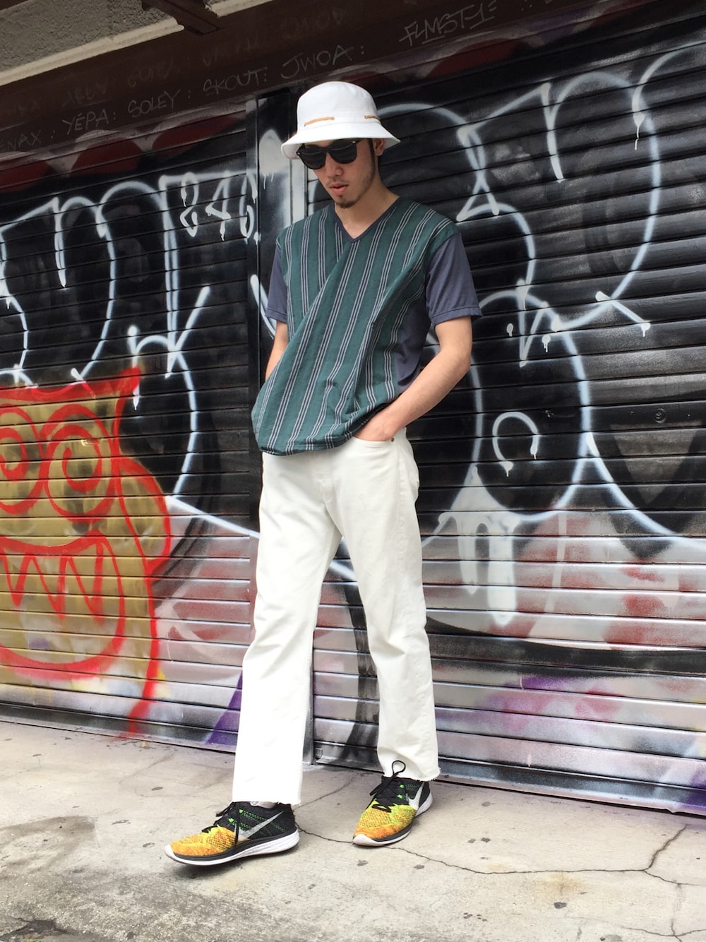 「バケットハット、supreme、春色、白パンツ、NIKE、ランニングシューズ、UPSTART×BURKS.BULL、FLYKNIT、J.CREW、サングラス」｜「J.CREWのアイテム（Tシャツ/カットソー、グリーン系）」を使った、TOMOYAさん（メンズ・174cm）の春コーディネートの1枚目の写真