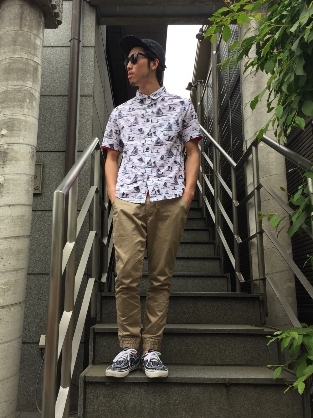 「シャツスタイル、ジェットキャップ、サングラス、レイバン、総柄トップス、イージーパンツ、VANS、supreme、UPSTART×BURKS.BULL、スニーカー」｜「UP STARTのアイテム（シャツ/ブラウス、ブルー系）」を使った、TOMOYAさん（メンズ・174cm）の春コーディネートの1枚目の写真