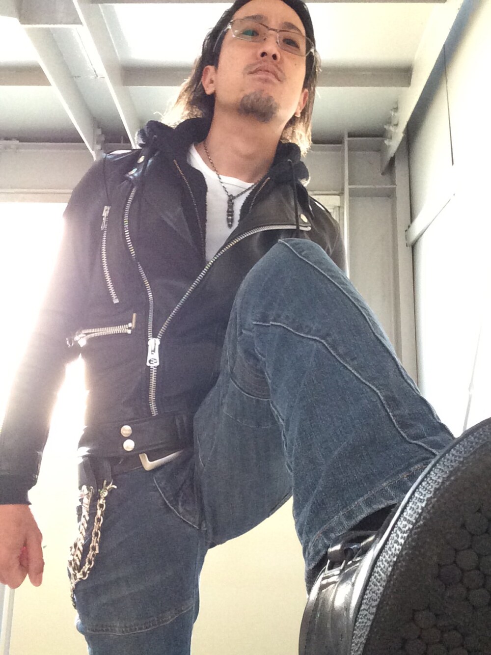 ブラック系のパーカー、ブラック系のブルゾン、ブルー系のデニムパンツを着用したメンズの冬コーディネートの1枚目の写真