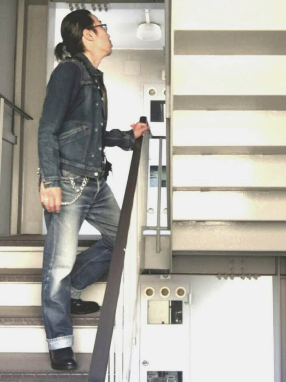 ブルー系のデニムジャケット、ブラック系のブーツ、ブルー系のデニムパンツを着用したメンズの秋コーディネートの1枚目の写真