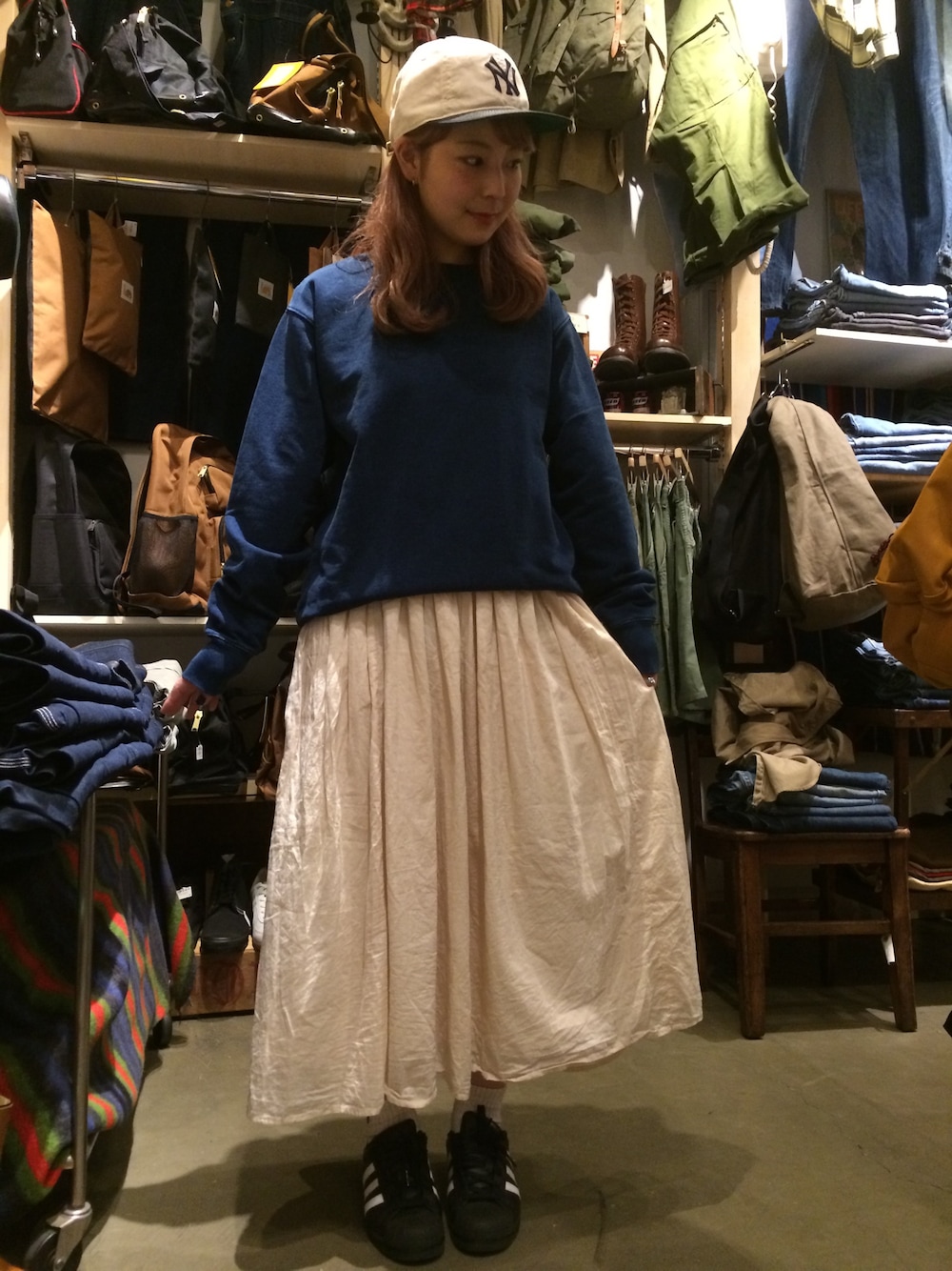 ブルー系のスウェット、ホワイト系のキャップを着用したレディースの春コーディネートの1枚目の写真