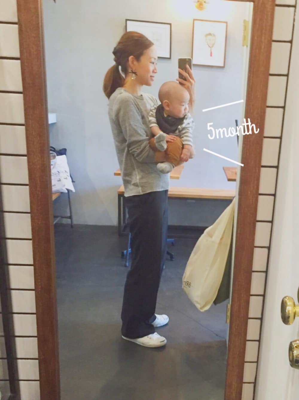 グレー系のTシャツ/カットソー、ブラック系のスラックス、ホワイト系のスニーカーを着用したレディースの秋コーディネートの1枚目の写真