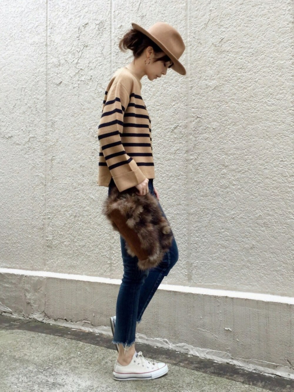 ベージュ系のニット/セーター、デニムパンツ、ホワイト系のスニーカーを着用したレディースの秋コーディネートの1枚目の写真