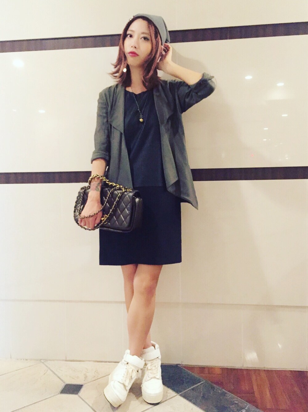 ブラック系のワンピース、ブラウン系のハンドバッグを着用したレディースの秋コーディネートの1枚目の写真