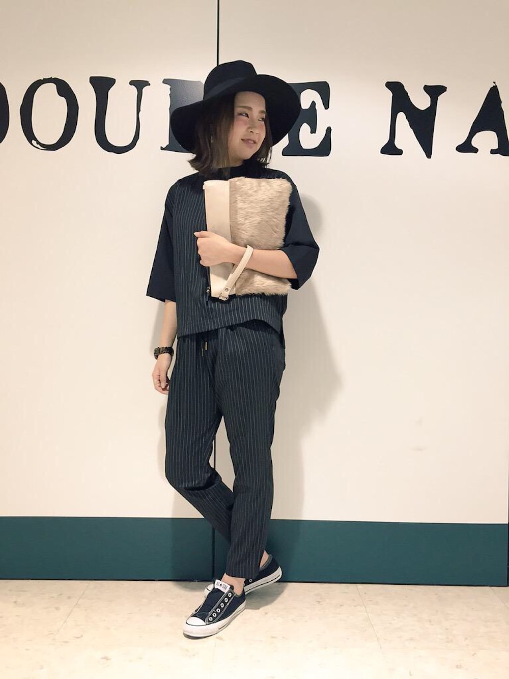 ブラック系のシャツ/ブラウス、ブラック系のその他パンツ、ベージュ系のクラッチバッグを着用したレディースの夏コーディネートの1枚目の写真