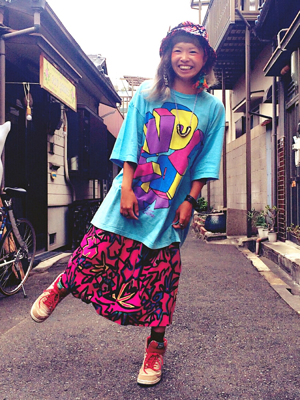ブルー系のTシャツ/カットソー、ピンク系のスカート、ホワイト系のスニーカーを着用したレディースの秋コーディネートの1枚目の写真