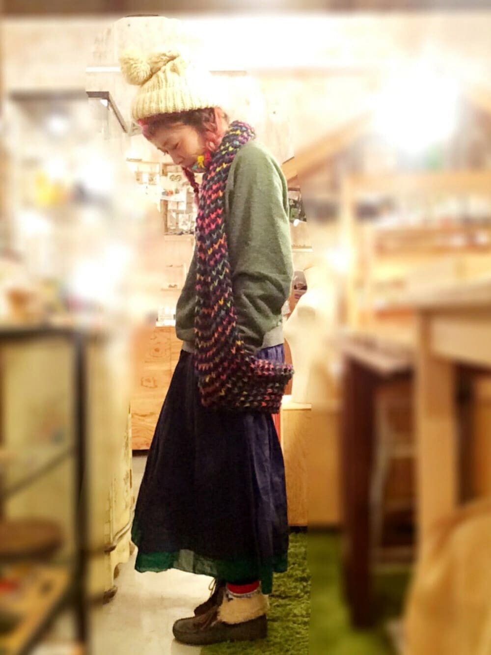 グレー系のスウェット、グリーン系のスカート、グレー系のシューズを着用したレディースの秋コーディネートの1枚目の写真