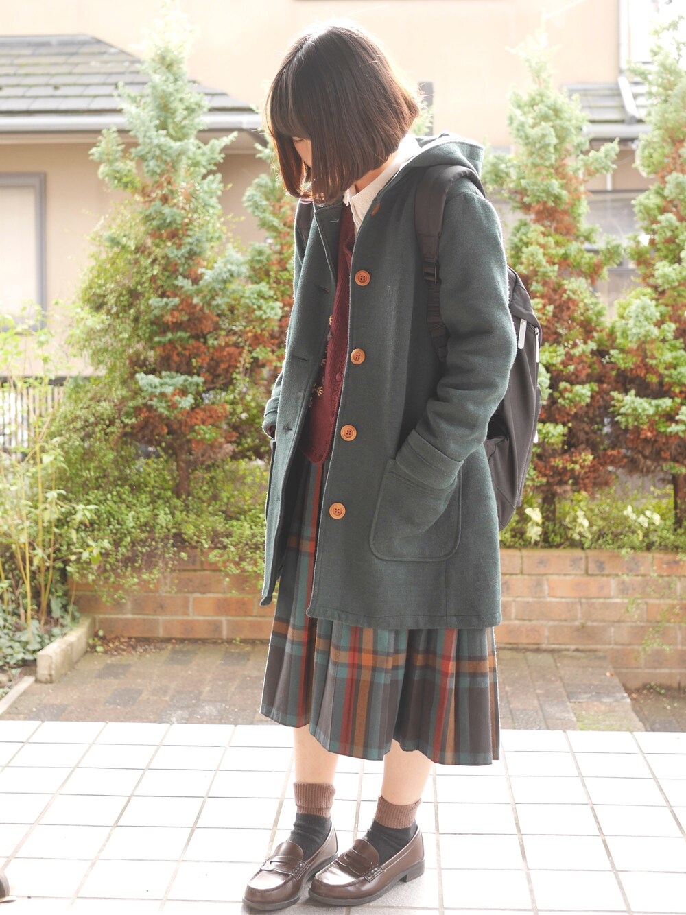 グリーン系のその他アウター、レッド系のカーディガン/ボレロ、グリーン系のスカートを着用したレディースの冬コーディネートの1枚目の写真