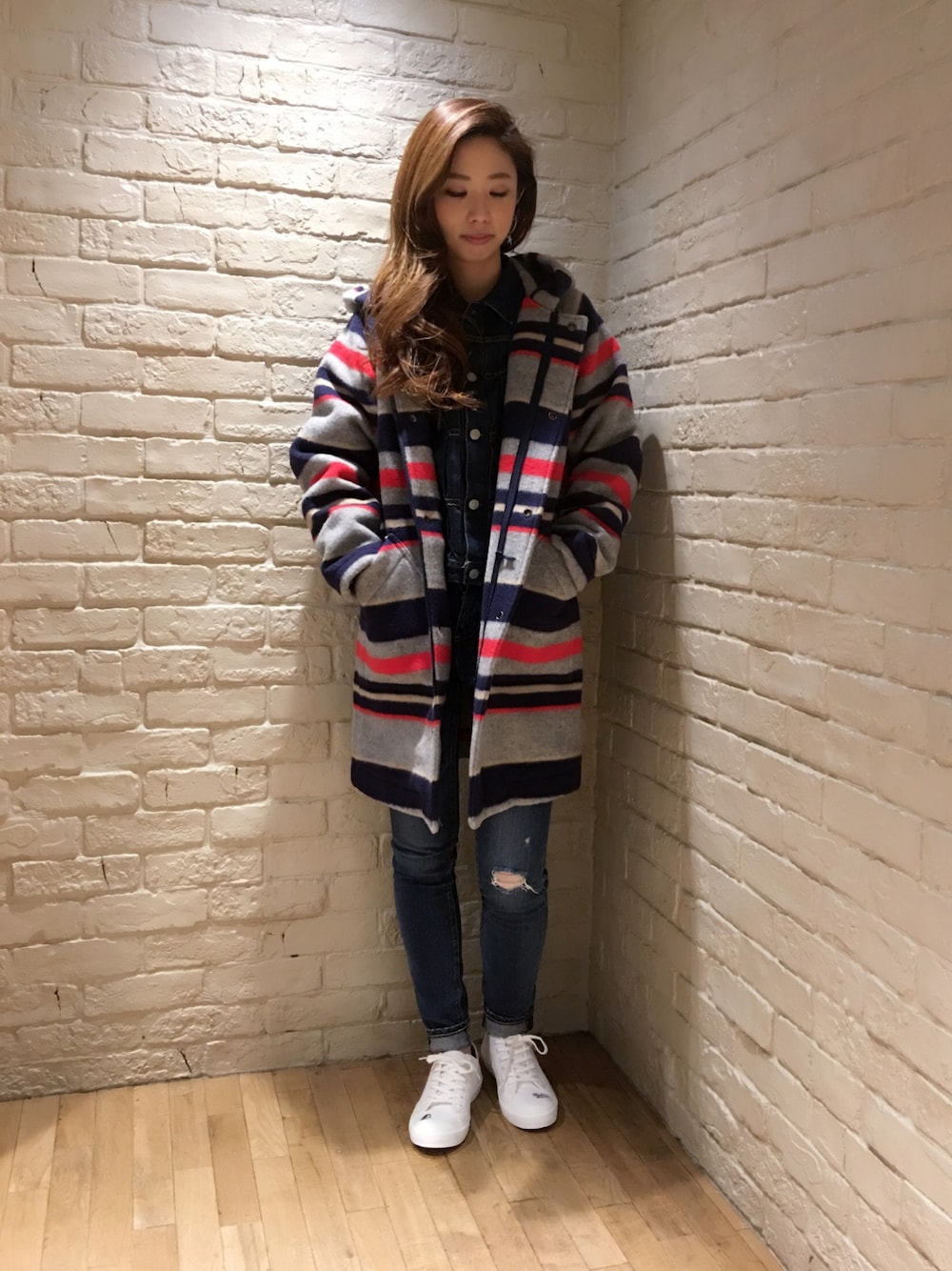 グレー系のダッフルコート、ブルー系のデニムジャケット、ブルー系のデニムパンツを着用したレディースの秋コーディネートの1枚目の写真