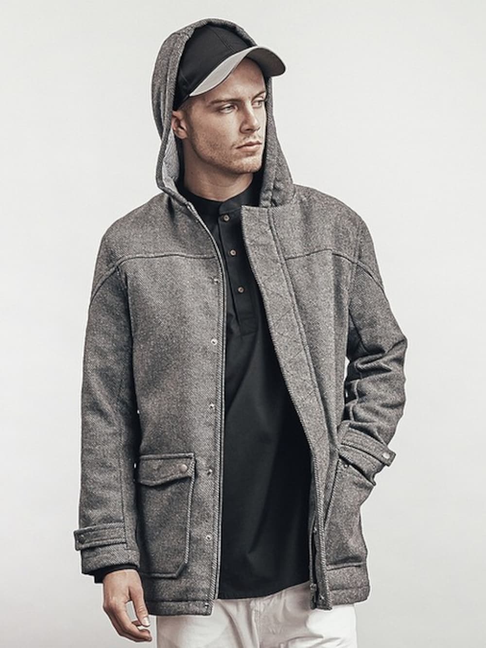 グレー系のダッフルコート、ブラック系のシャツ/ブラウス、ブルー系のキャップを着用したメンズの春コーディネートの1枚目の写真