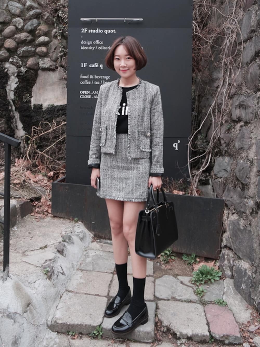 グレー系のノーカラージャケット、グレー系のスカートを着用したレディースの春コーディネートの1枚目の写真