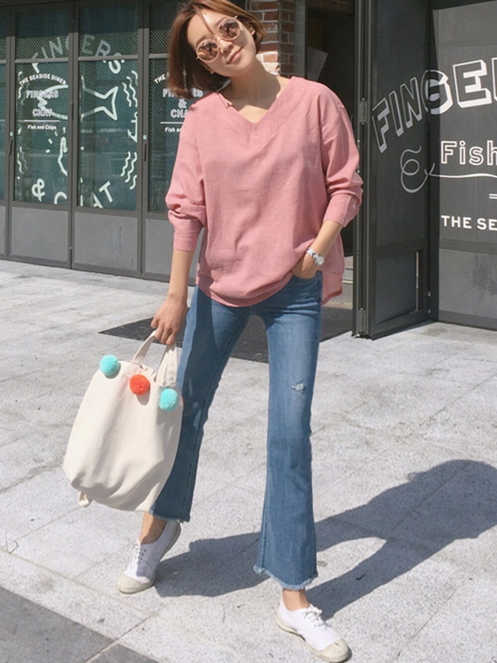 ピンク系のシャツ/ブラウス、ブルー系のデニムパンツ、ホワイト系のエコバッグ/サブバッグを着用したレディースの春コーディネートの1枚目の写真