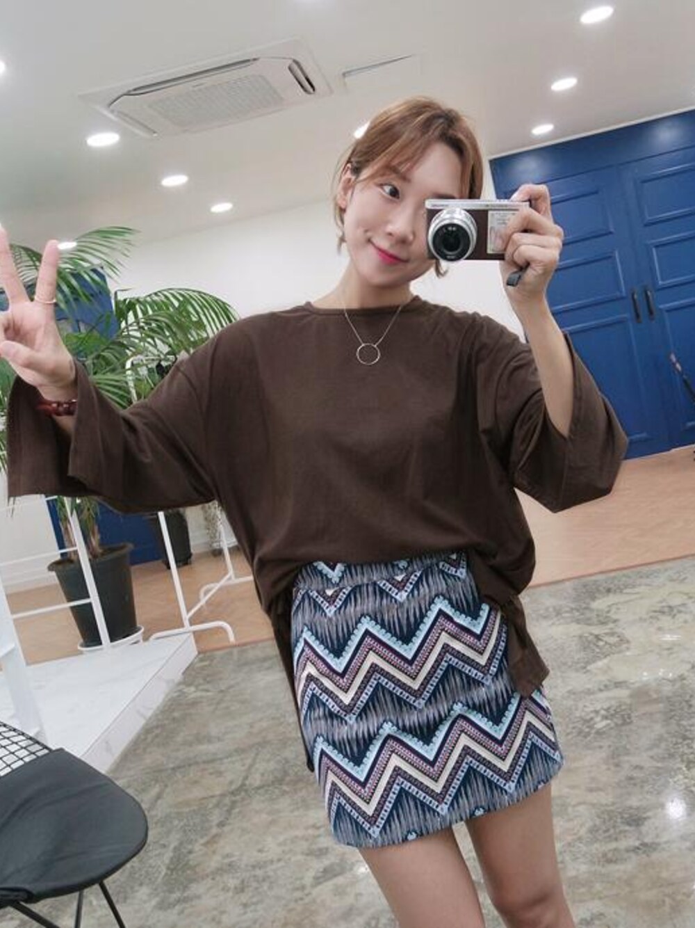グレー系のスカート、ブラウン系のTシャツ/カットソーを着用したレディースの夏コーディネートの1枚目の写真