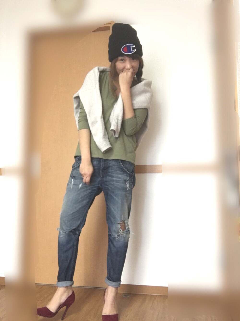 グリーン系のTシャツ/カットソー、ベージュ系のニット/セーター、ブルー系のデニムパンツを着用したレディースの春コーディネートの1枚目の写真