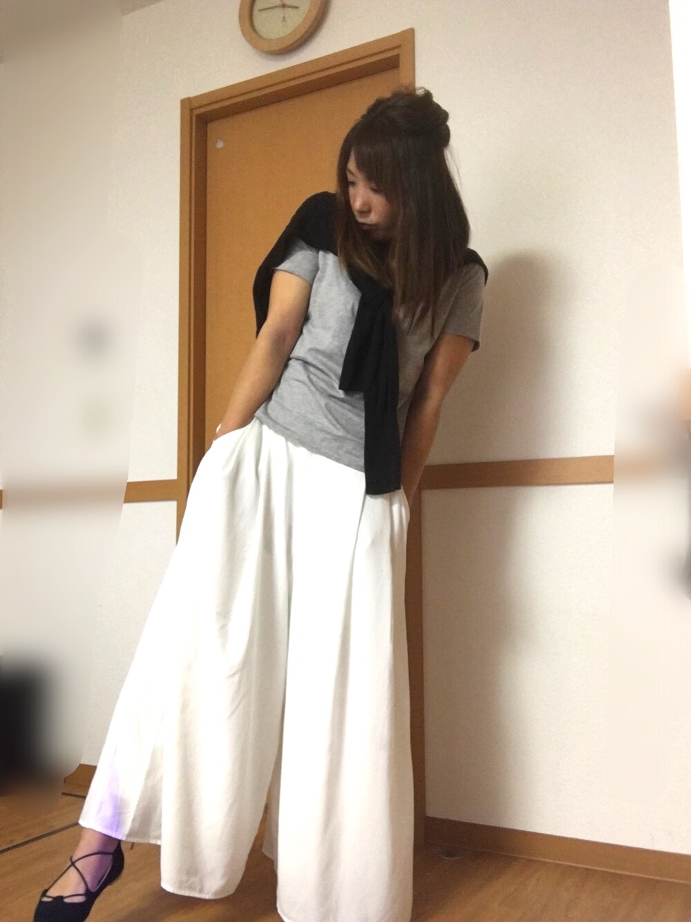 グレー系のTシャツ/カットソー、ブラック系のニット/セーター、ホワイト系のその他パンツを着用したレディースの春コーディネートの1枚目の写真