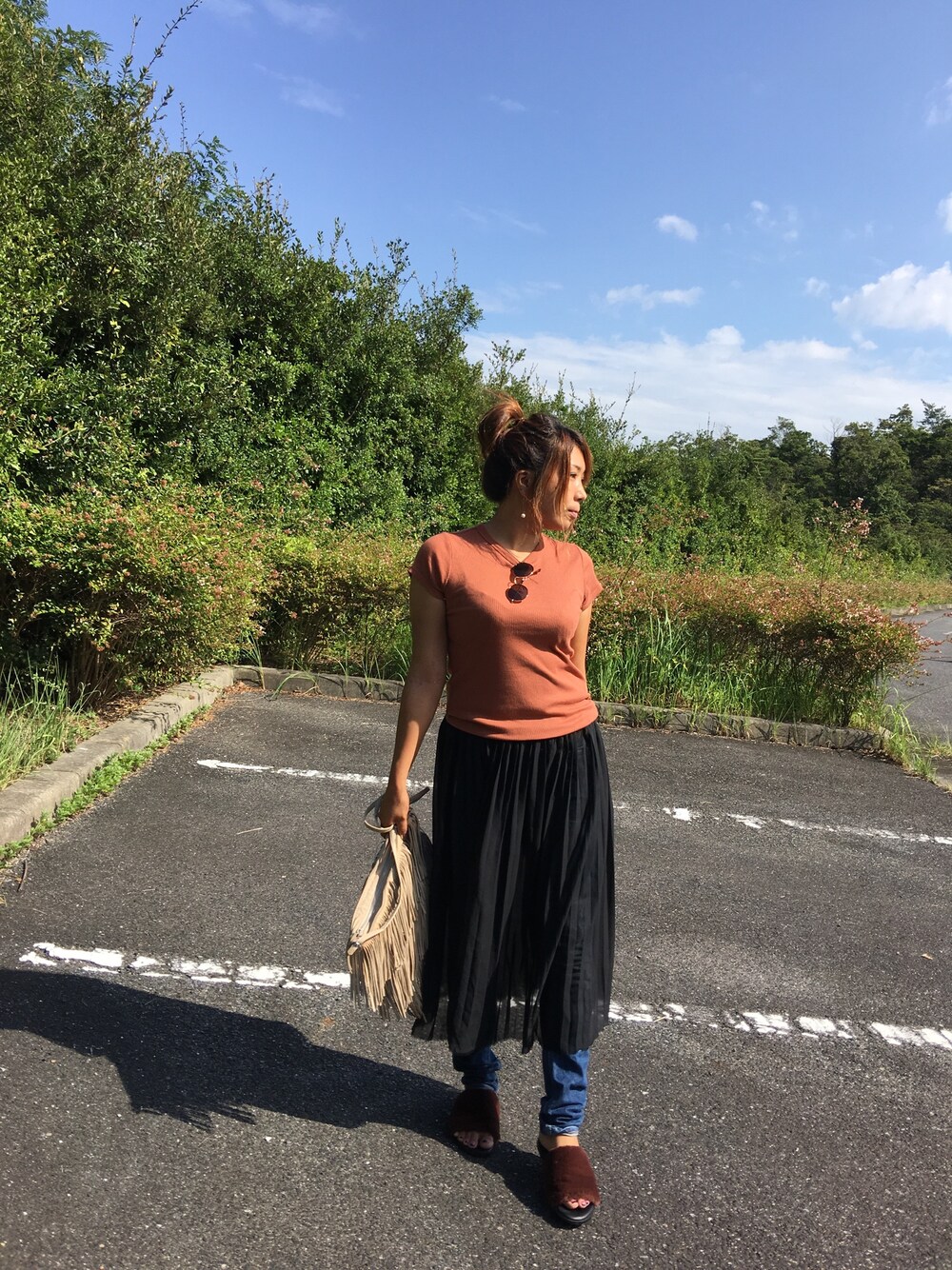 ブラック系のスカート、ブルー系のデニムパンツ、ベージュ系のショルダーバッグを着用したレディースの秋コーディネートの1枚目の写真