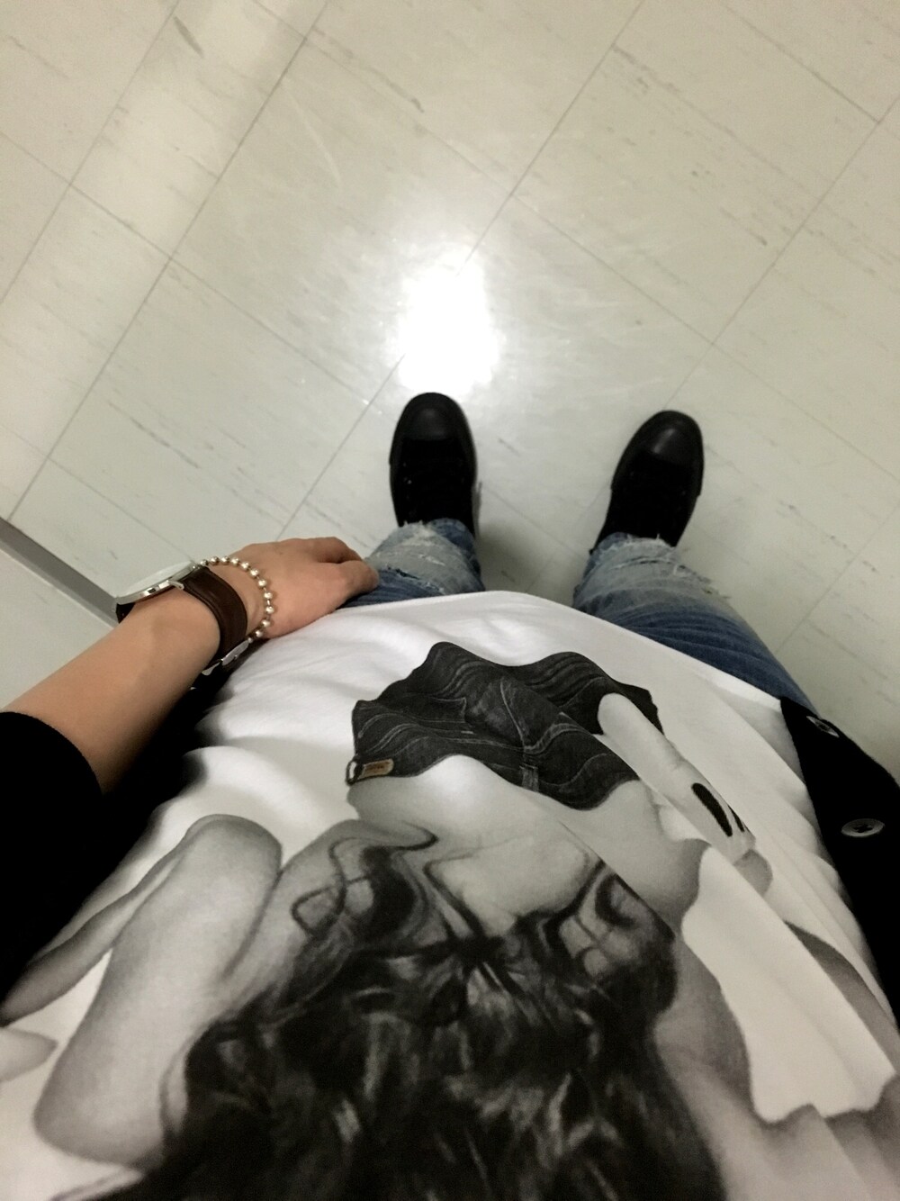 ホワイト系のTシャツ/カットソー、ブラック系のカーディガン/ボレロ、ブルー系のデニムパンツを着用したメンズの秋コーディネートの1枚目の写真