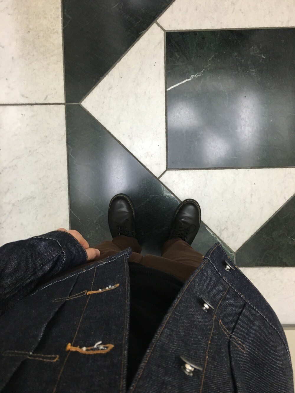 ブラック系のブーツ、ブラウン系のチノパンツ、ブルー系のデニムジャケットを着用したメンズの秋コーディネートの1枚目の写真