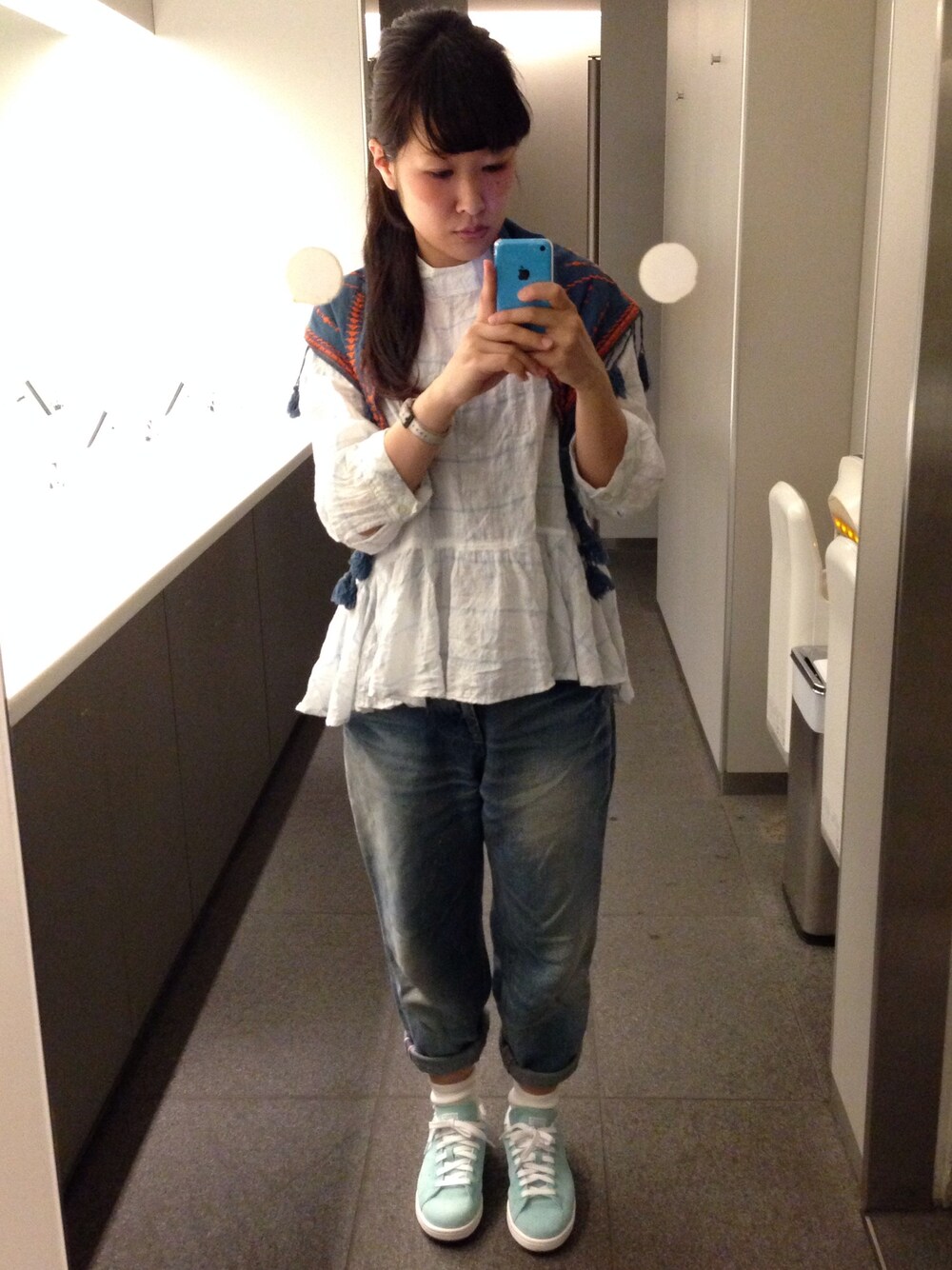 ブルー系のデニムパンツ、グリーン系のスニーカー、ホワイト系のシャツ/ブラウスを着用したレディースの春コーディネートの1枚目の写真