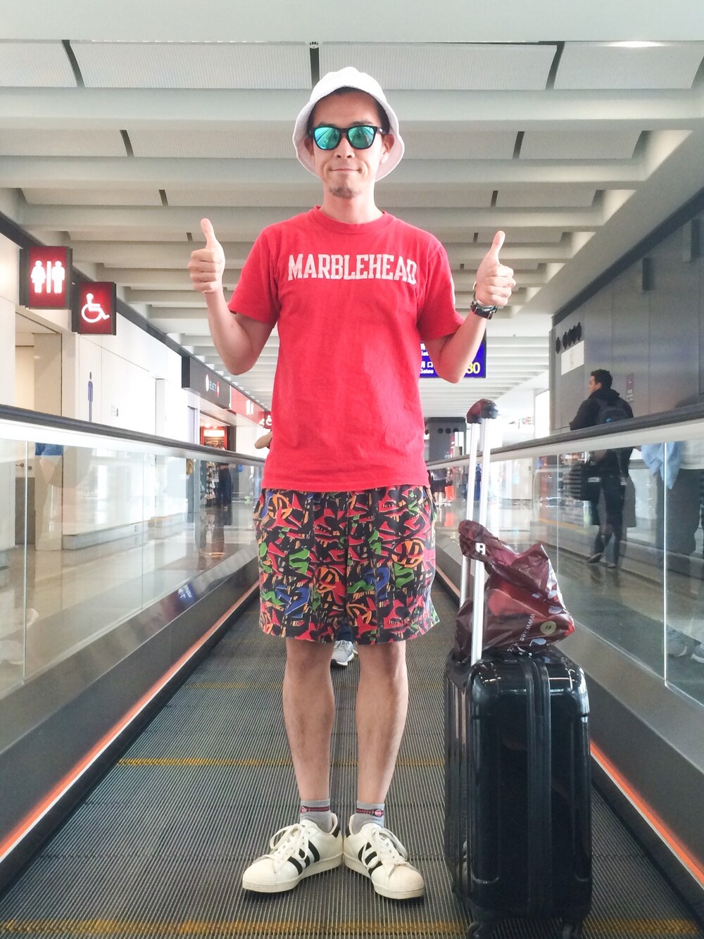 レッド系のTシャツ/カットソー、レッド系のその他パンツ、ホワイト系のスニーカーを着用したメンズの秋コーディネートの1枚目の写真