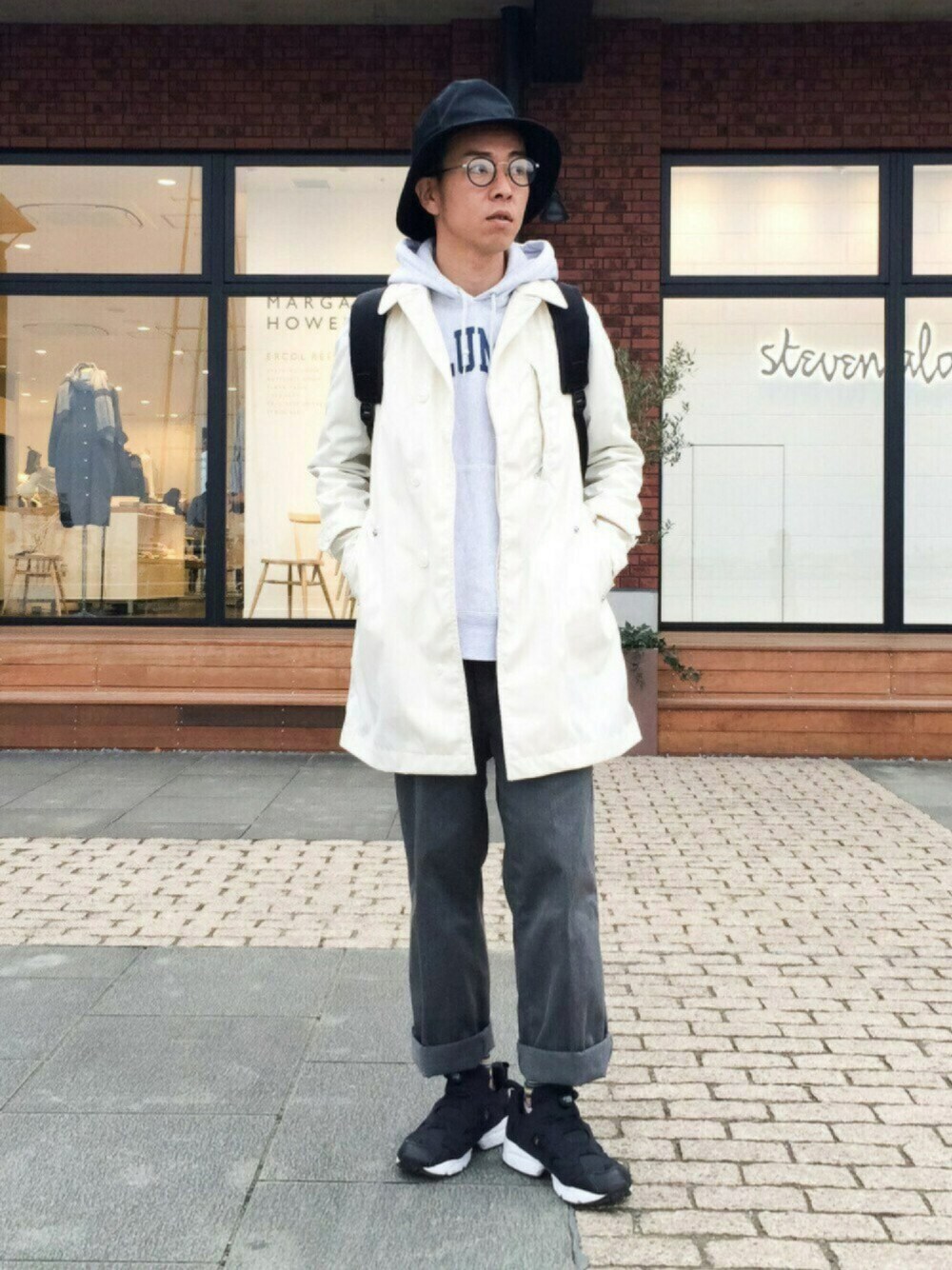 ホワイト系のマウンテンパーカー、グレー系のパーカー、ブラック系のバックパック/リュックを着用したメンズの春コーディネートの1枚目の写真