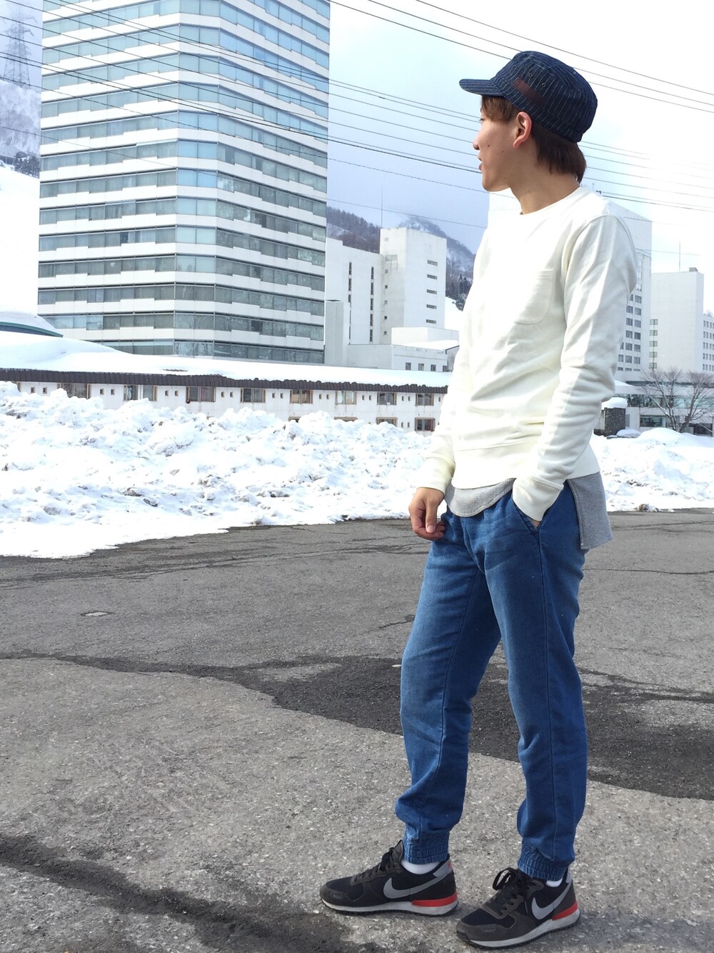 ブラック系のスニーカー、グレー系のTシャツ/カットソー、ブルー系のデニムパンツを着用したメンズの春コーディネートの1枚目の写真