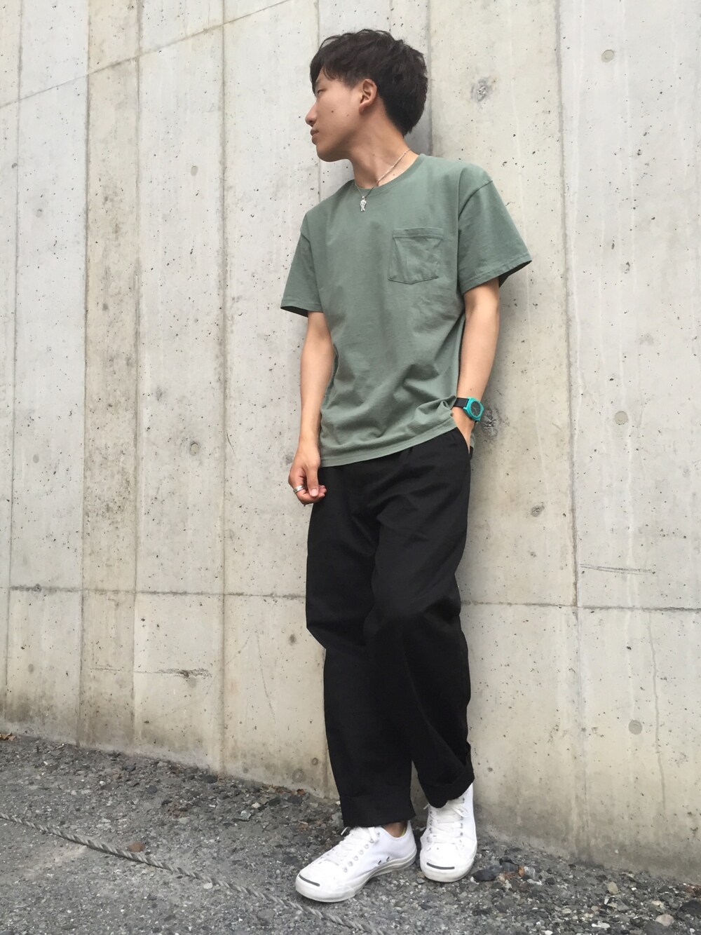 ホワイト系のスニーカー、グリーン系のTシャツ/カットソー、ブラック系のスラックスを着用したメンズの春コーディネートの1枚目の写真