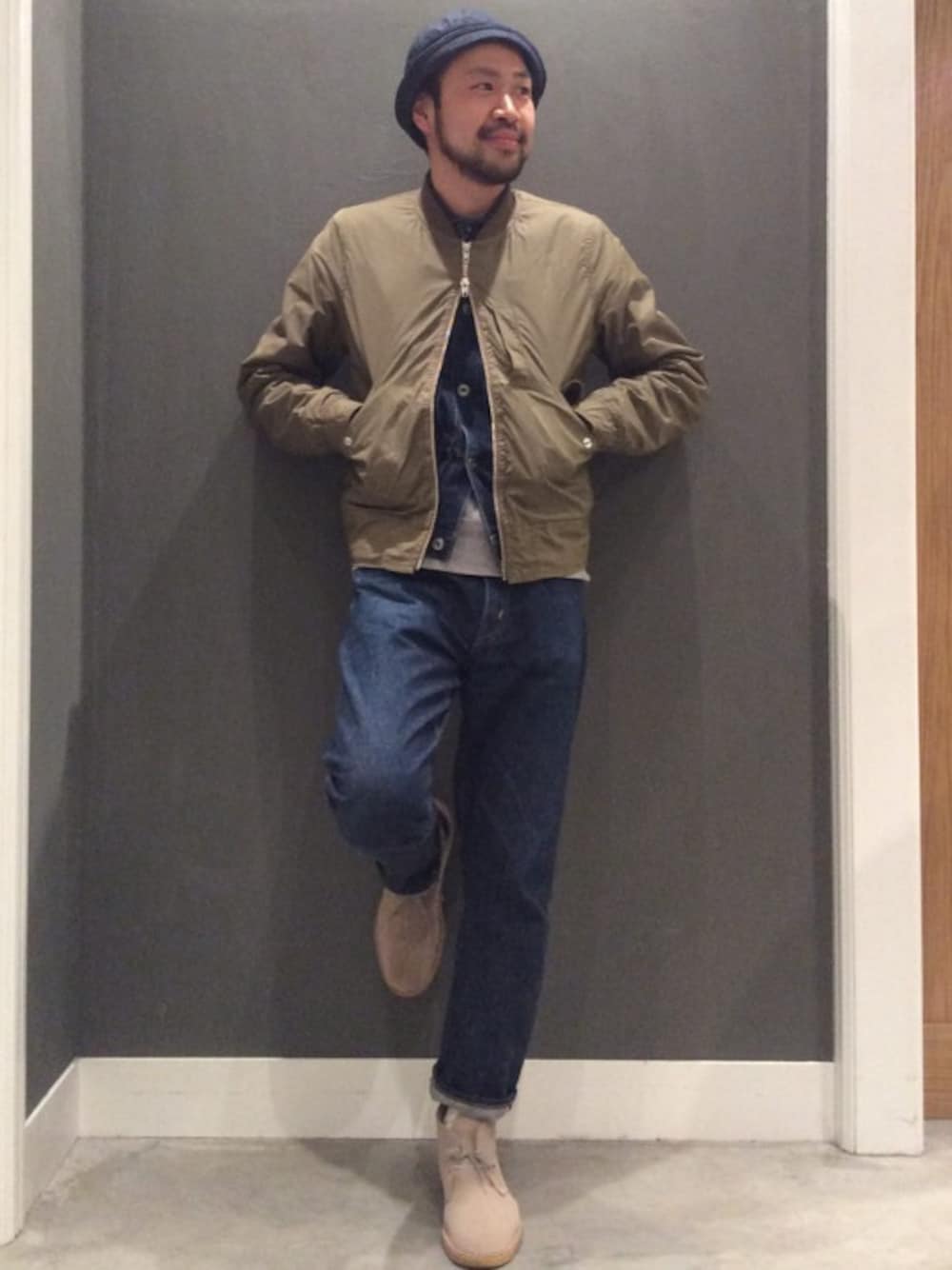グリーン系のブルゾン、ブルー系のハットを着用したメンズの春コーディネートの1枚目の写真