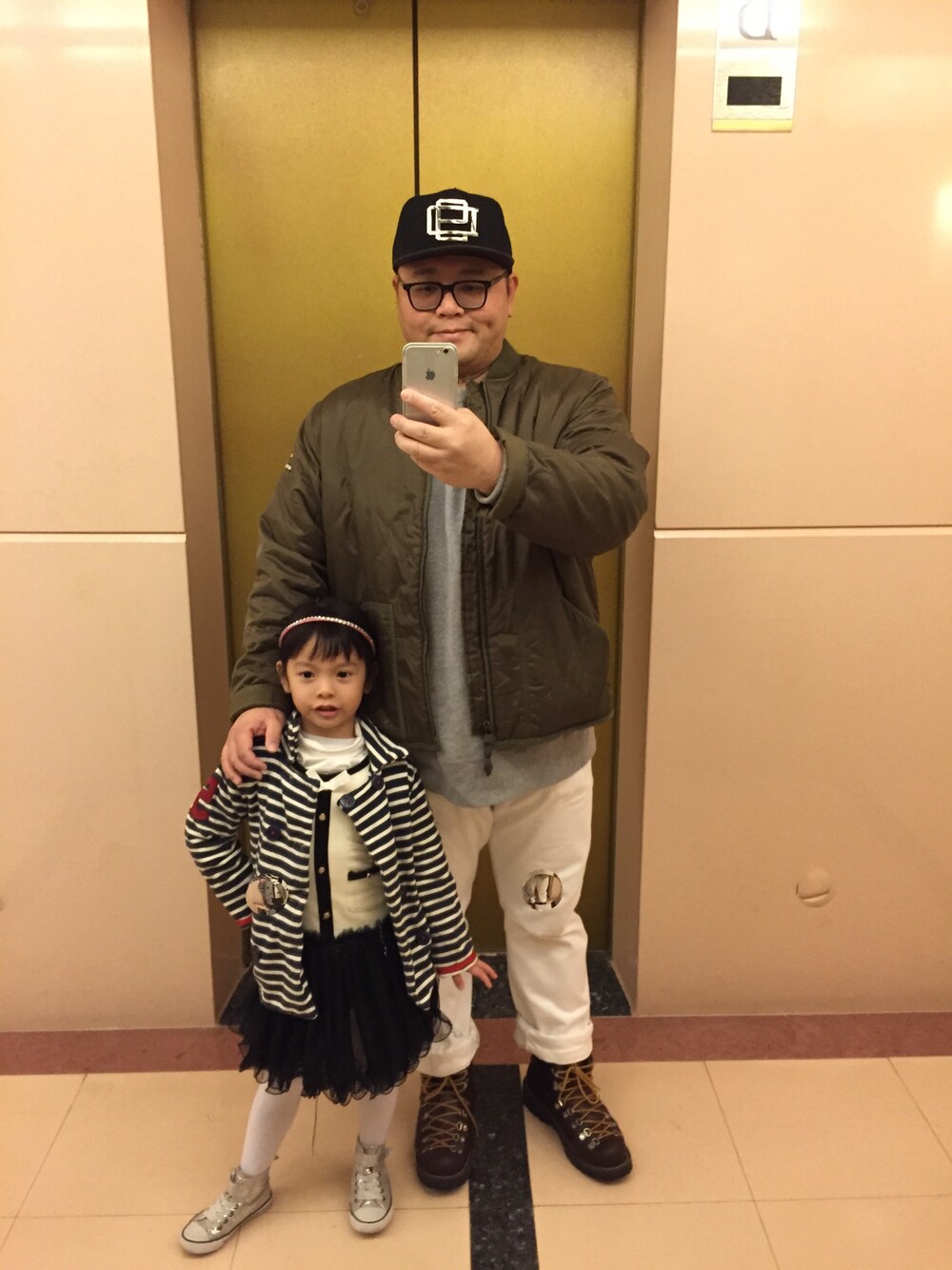 グリーン系のナイロンジャケットを着用したメンズの冬コーディネートの1枚目の写真